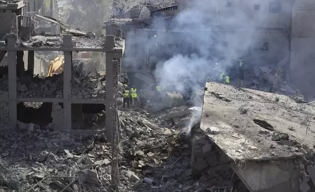 Rescue workers search for victims at the site that was hit by Israeli airstrikes in Qana village, south Lebanon, Wednesday, Oct. 16, 2024. (AP Photo/Mohammed Zaatari)