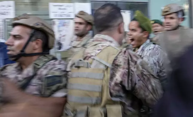 People displaced by Israel's war on Hezbollah scuffle with members of the Lebanese security, after dozens of policemen arrived at the building to evict the displaced from the private property, in Beirut, Lebanon, Monday, Oct. 21, 2024. (AP Photo/Hassan Ammar)