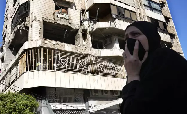 A woman reacts in front an apartment in a multistory building hit by Israeli airstrike, in central Beirut, Lebanon, Thursday, Oct. 3, 2024. (AP Photo/Hussein Malla)