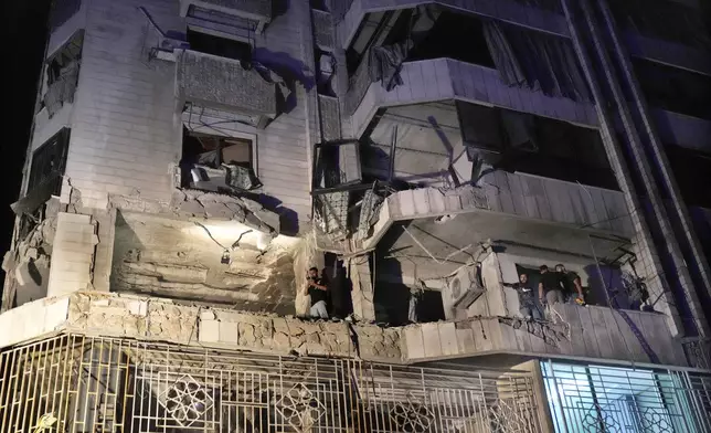 Rescue workers survey an apartment hit by an airstrike in Beirut, Lebanon, Thursday, Oct. 3, 2024. (AP Photo/Hussein Malla)