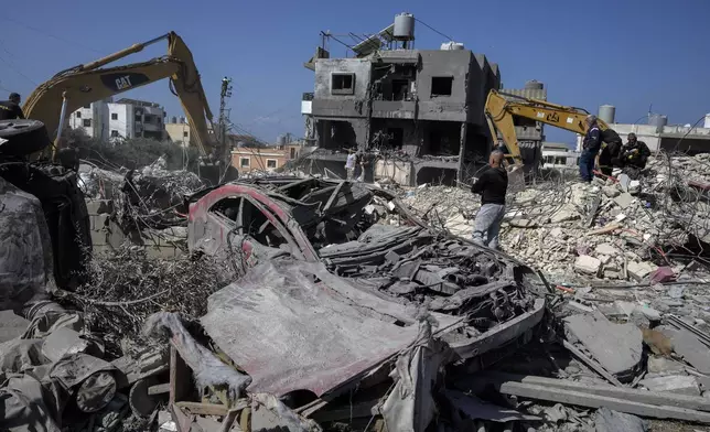 Rescue workers use excavators to remove the rubble of a destroyed building that was hit Tuesday night in an Israeli airstrike, as they search for victims in Sarafand, south Lebanon, Wednesday, Oct. 30, 2024. (AP Photo/Bilal Hussein)