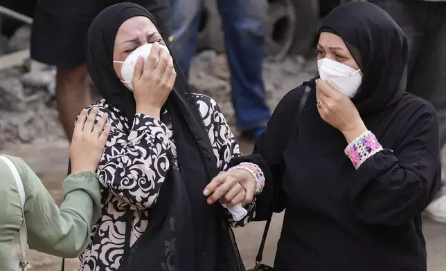 Women react in front of their destroyed apartment at the site of Thursday's Israeli airstrike in Beirut, Lebanon, Friday, Oct. 11, 2024. (AP Photo/Hassan Ammar)