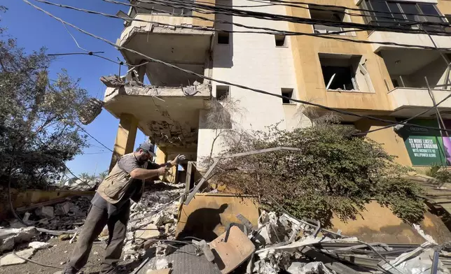 A worker removes the debris of a building that housed the office of pan-Arab TV channel Al-Mayadeen, which is politically allied with Hezbollah, that was hit Wednesday night by an Israeli airstrike, in southern Beirut, Lebanon, Thursday, Oct. 24, 2024. (AP Photo/Hussein Malla)