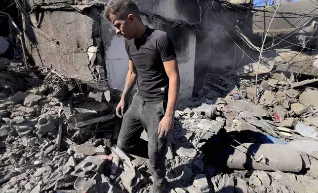 A man walks at the site of Israeli airstrikes that destroyed buildings facing the city's main government hospital in a densely-populated neighborhood, in southern Beirut, Lebanon, Tuesday, Oct. 22, 2024.(AP Photo/Hussein Malla)w