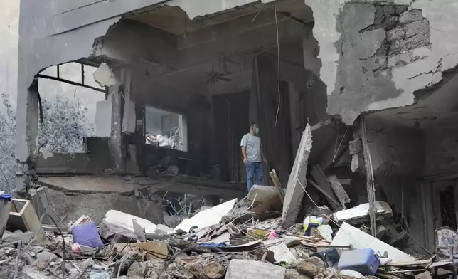 A man checks his destroyed house at the site of Thursday's Israeli airstrike, in Beirut, Lebanon, Friday, Oct. 11, 2024. (AP Photo/Hussein Malla)