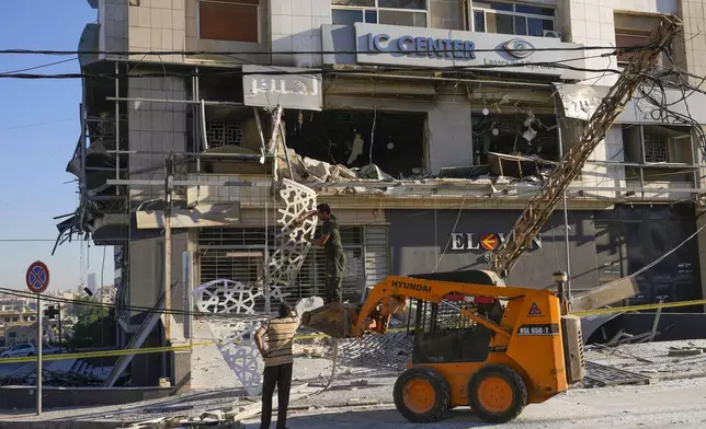 Rescue workers use a skid loader to remove rubble at the site of an Israeli airstrike that hit several branches of the Hezbollah-run al-Qard al-Hassan in Dahiyeh, Beirut, Lebanon, Monday, Oct. 21, 2024. (AP Photo/Hassan Ammar)