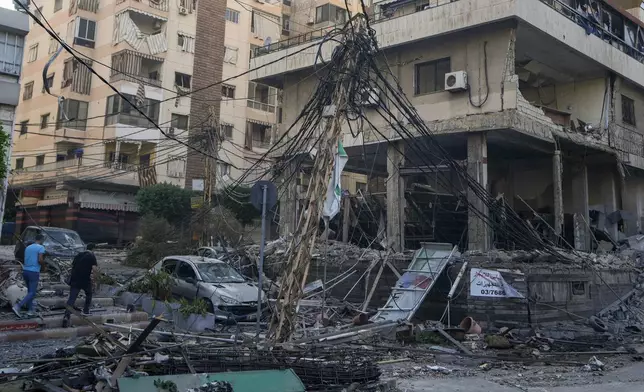 People check the site of an Israeli airstrike in Dahiyeh, Beirut, Lebanon, Sunday, Oct. 6, 2024. (AP Photo/Bilal Hussein)