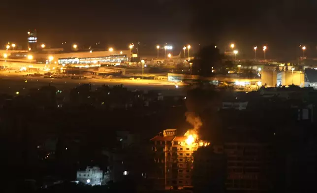 Flames and smoke rise from a building that was hit by an Israeli airstrike in Dahiyeh, as Rafik Hariri International airport is seen in the background, in Beirut, Lebanon, Friday, Oct. 4, 2024. (AP Photo/Hussein Malla)