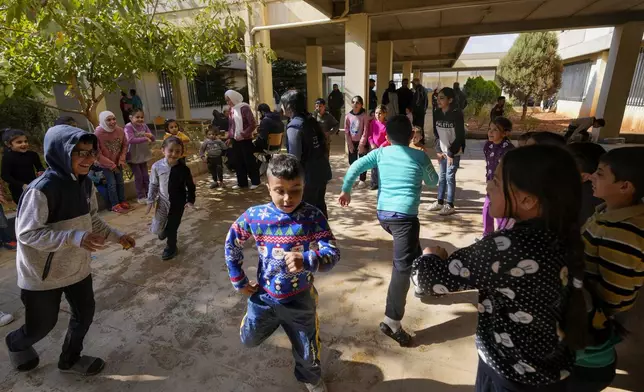 Displaced children, who fled Baalbek city and the nearby towns of Douris and Ain Bourday with their families amid the ongoing Hezbollah-Israel war, play at a school being used as a shelter, in Deir Al-Ahmar, east Lebanon, Thursday, Oct. 31, 2024. (AP Photo/Hassan Ammar)