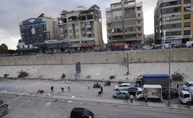 Rescuers arrive at the site of a building that was hit in an Israeli airstrike in Bir Hassan, Beirut, Lebanon, Tuesday, Oct. 1, 2024. (AP Photo/Hussein Malla)