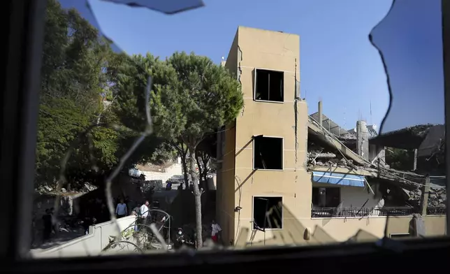A destroyed hotel-turned-shelter for displaced people hit by an Israeli airstrike is seen through a broken window, in Wardaniyeh, south Lebanon, Wednesday, Oct. 9, 2024. (AP Photo/Mohammed Zaatari)