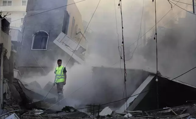 A rescue worker checks a destroyed building hit in an Israeli airstrike in Tyre, southern Lebanon, Monday, Oct. 28, 2024.(AP Photo/Mohammed Zaatari)