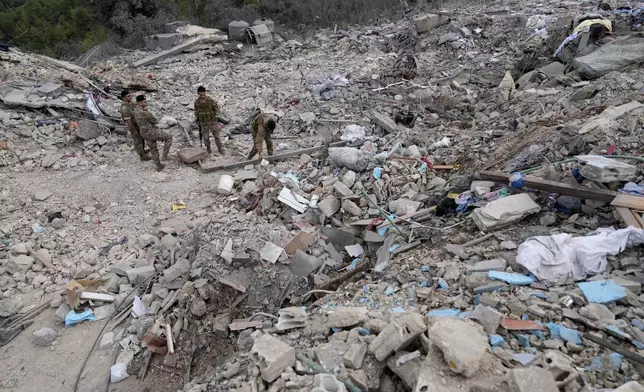 Lebanese army soldiers search on the rubble of a destroyed building at the site of Monday's Israeli airstrike in Aito village, north Lebanon, Tuesday, Oct. 15, 2024. (AP Photo/Hussein Malla)