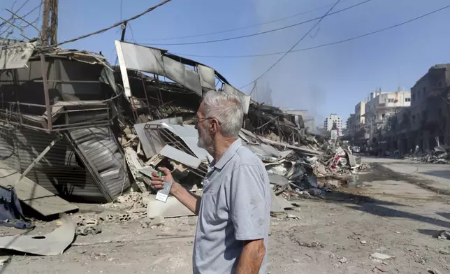 Lebanese man Ahmad Fakih checks his destroyed coffeeshop at a commercial street that was hit Saturday night by Israeli airstrikes, in Nabatiyeh town, south Lebanon, Sunday, Oct. 13, 2024. (AP Photo/Mohammed Zaatari)