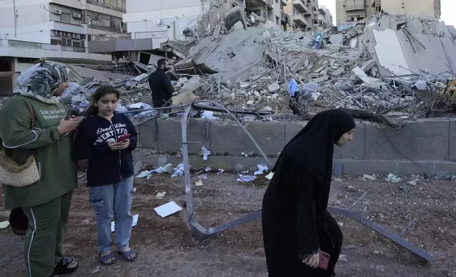 Residents check destroyed buildings at the site of an Israeli airstrike in Dahiyeh, Beirut, Lebanon, Monday, Oct. 21, 2024. (AP Photo/Hassan Ammar)