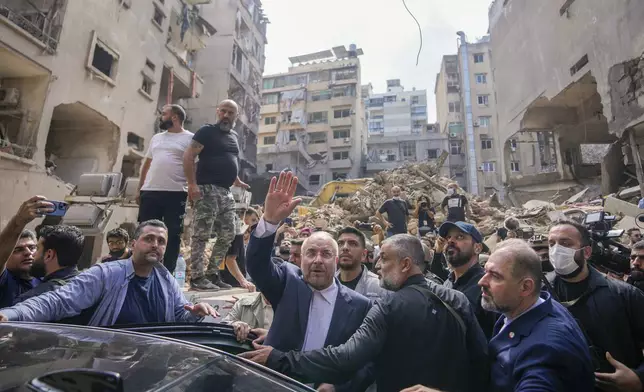 Iran's parliament speaker Mohammad Bagher Qalibaf waves to residents as visit the site of Thursday's Israeli airstrike, in Beirut, Lebanon, Saturday, Oct. 12, 2024. (AP Photo/Hassan Ammar)