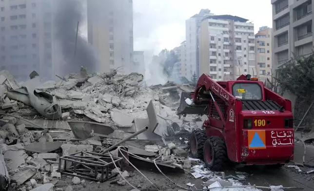 Civil Defense remove debris from a destroyed complex hit in Israeli airstrikes in Dahieh, Beirut, Lebanon, Wednesday, Oct. 2, 2024. (AP Photo/Hussein Malla)