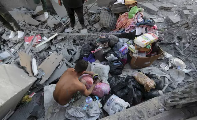 A Lebanese man collects belongings from his destroyed apartment that was hit by an Israeli airstrike, in Tyre, south Lebanon, Thursday, Oct. 24, 2024. (AP Photo/Mohammed Zaatari)