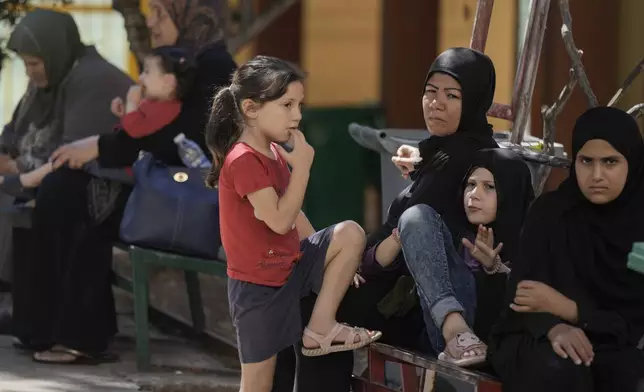 Displaced people sit at a vocational training center run by the U.N. agency for Palestinian refugees, or UNRWA, in the southern town of Sebline, south of Beirut, Lebanon, Friday, Oct. 4, 2024, after fleeing the Israeli airstrikes in the south. (AP Photo/Bilal Hussein)