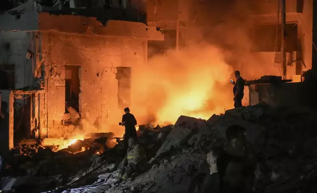 Flames and smoke rise at the scene of destroyed buildings hit by an Israeli airstrike in central Beirut, Lebanon, Thursday, Oct. 10, 2024. (AP Photo/Bilal Hussein)