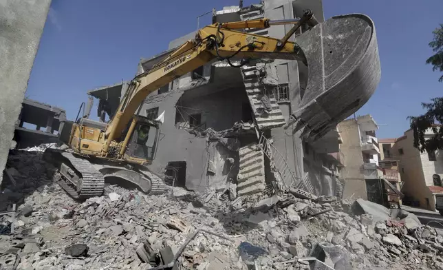 An excavator is used by a rescue worker to remove the rubble of destroyed buildings at the site that was hit by Israeli airstrikes in Qana village, south Lebanon, Wednesday, Oct. 16, 2024. (AP Photo/Mohammed Zaatari)