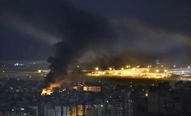 Flames and smoke rise form an Israeli airstrike, as Rafik Hariri international airport seen on the background, in the southern suburb of Beirut, Lebanon, Sunday, Oct. 20, 2024. (AP Photo/Hussein Malla)