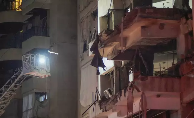 A rescue worker searches for survivors inside a damaged building hit by an Israeli airstrike in Beirut, Lebanon, Thursday, Oct. 10, 2024. (AP Photo/Hassan Ammar)