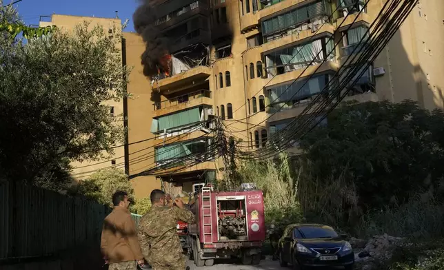 Lebanese soldiers stand in front of an apartment which caught fire after an Israeli airstrike in Dahieh, Beirut, Lebanon, Wednesday, Oct. 2, 2024. (AP Photo/Hussein Malla)