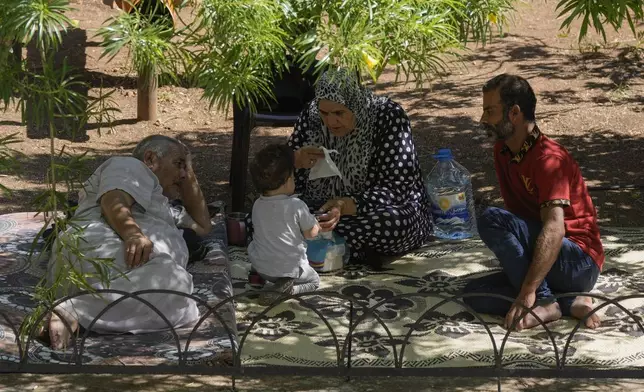 Displaced people sit at a vocational training center run by the U.N. agency for Palestinian refugees, or UNRWA, in the southern town of Sebline, south of Beirut, Lebanon, Friday, Oct. 4, 2024, after fleeing the Israeli airstrikes in the south. (AP Photo/Bilal Hussein)