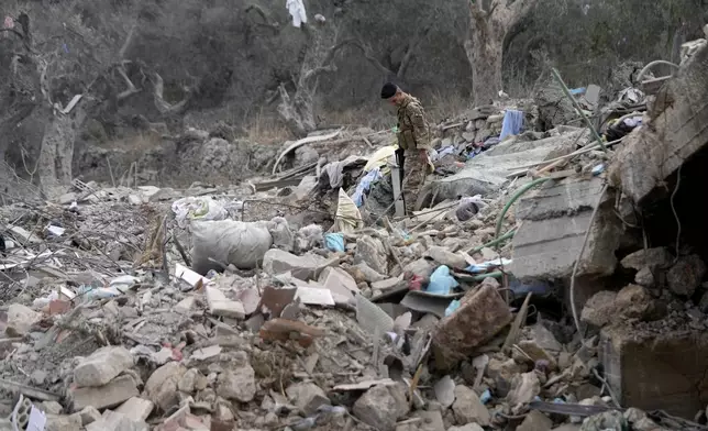 A Lebanese army soldiers walks on the rubble of a destroyed building at the site of Monday's Israeli airstrike in Aito village, north Lebanon, Tuesday, Oct. 15, 2024. (AP Photo/Hussein Malla)