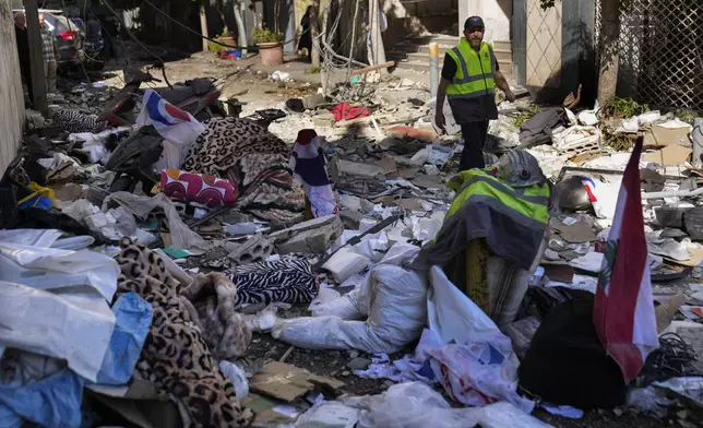 A Hezbollah paramedic walks between debris after an airstrike hit an apartment in a multistory building, in central Beirut, Lebanon, Thursday, Oct. 3, 2024. (AP Photo/Hussein Malla)