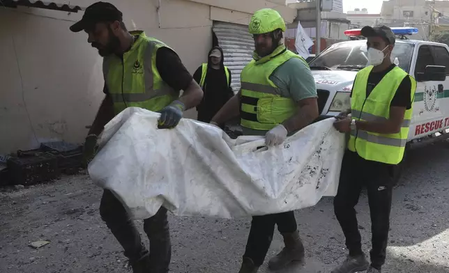 Rescue workers carry remains of killed people at the site that was hit by Israeli airstrikes in Qana village, south Lebanon, Wednesday, Oct. 16, 2024. (AP Photo/Mohammed Zaatari)