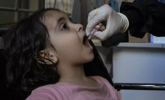 Angelina, who is fleeing the Israeli airstrikes with her family from Dahiyeh, receives a polio vaccine in an empty building complex, in Beirut, Lebanon, Wednesday, Oct. 9, 2024. (AP Photo/Bilal Hussein)