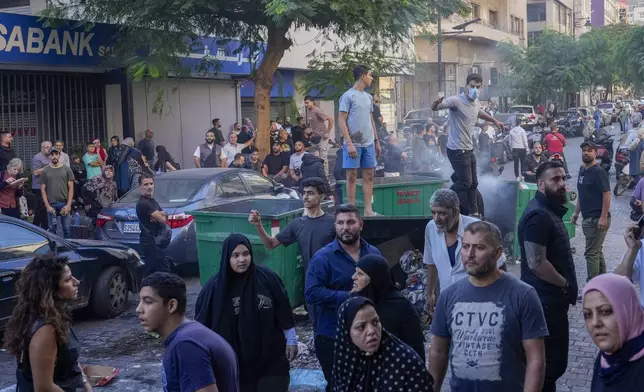 People displaced by Israel's war on Hezbollah gesture after scuffle with members of the Lebanese security, after dozens of policemen arrived at the building to evict the displaced from the private property, in Beirut, Lebanon, Monday, Oct. 21, 2024. (AP Photo/Hassan Ammar)