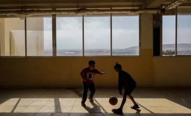 Displaced children, who fled Baalbek city and the nearby towns of Douris and Ain Bourday with their families amid the ongoing Hezbollah-Israel war, play at a school being used as a shelter, in Deir Al-Ahmar, east Lebanon, Thursday, Oct. 31, 2024. (AP Photo/Hassan Ammar)