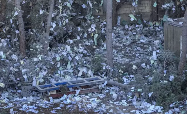 Documents of Hezbollah-run al-Qard al-Hassan are scattered at the site of an Israeli airstrike on Sunday night in Beirut's southern suburb, Lebanon, Monday, Oct. 21, 2024. (AP Photo/Hassan Ammar)