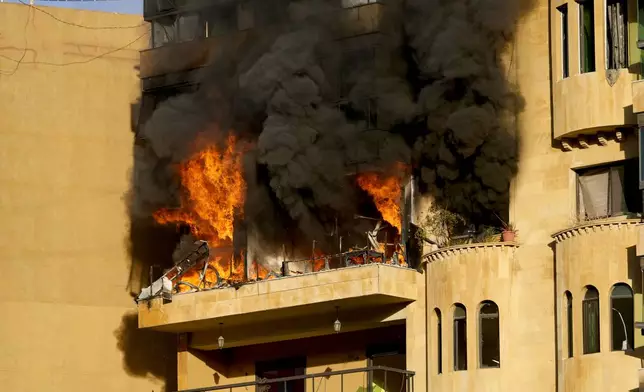 Flames rise from an apartment which caught fire after an Israeli airstrike in Dahieh, Beirut, Lebanon, Wednesday, Oct. 2, 2024. (AP Photo/Hussein Malla)