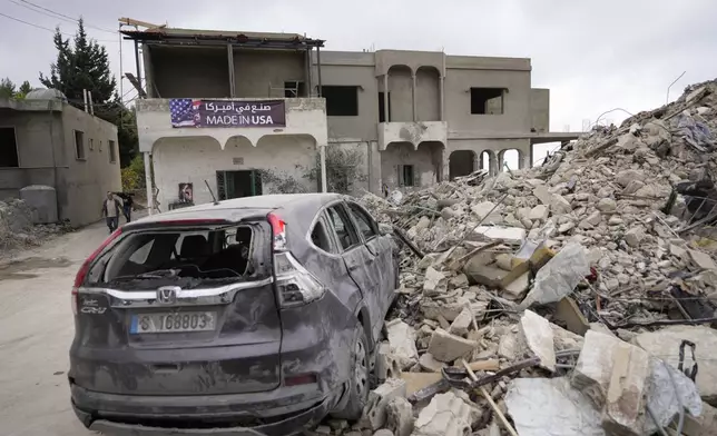 A car sits on the rubble of a building damaged in an Israeli airstrike, in Maisara near the northern coastal town of Byblos, Lebanon, Monday, Oct. 14, 2024. (AP Photo/Hassan Ammar)