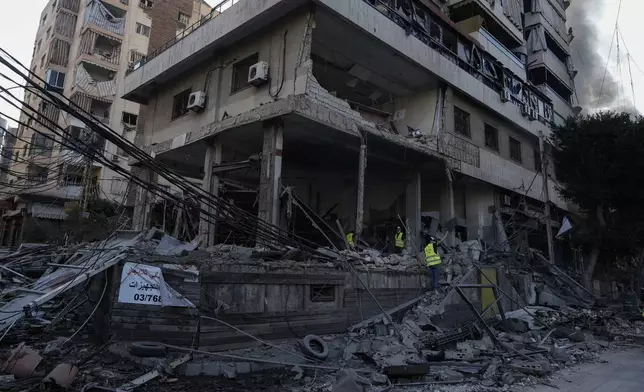 Emergency workers inspect a building that was hit in an Israeli airstrike in Dahiyeh, Beirut, Lebanon, Sunday, Oct. 6, 2024. (AP Photo/Bilal Hussein)