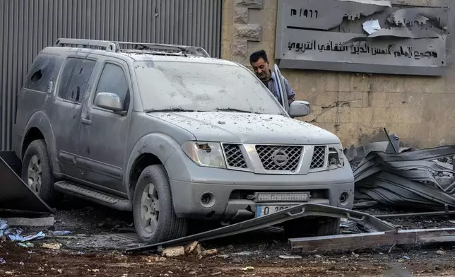 A man checks his destroyed car at the site of an Israeli airstrike that hit several branches of the Hezbollah-run al-Qard al-Hassan in Dahiyeh, Beirut, Lebanon, Monday, Oct. 21, 2024. (AP Photo/Hassan Ammar)