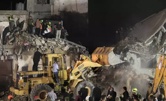 Rescue workers use a bulldozer to remove rubbles as they search for victims at a destroyed building hit in an Israeli airstrike, in the southern port city of Sidon, Lebanon, Tuesday, Oct. 29, 2024. (AP Photo/Mohammed Zaatari)