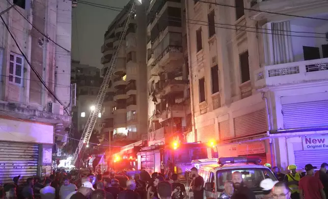 Rescue workers on a crane check a destroyed building hit by an Israeli airstrike in central Beirut, Lebanon, Thursday, Oct. 10, 2024. (AP Photo/Hassan Ammar)