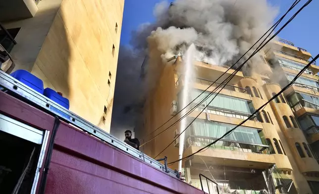 Civil defense firefighters try to extinguish the fire on an apartment following an Israeli airstrike in Dahieh, Beirut, Lebanon, Wednesday, Oct. 2, 2024. (AP Photo/Hussein Malla)