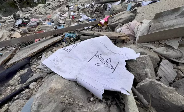 A drawing paper lies on the rubble of a destroyed building at the site of Monday's Israeli airstrike in Aito village, north Lebanon, Tuesday, Oct. 15, 2024. (AP Photo/Hussein Malla)