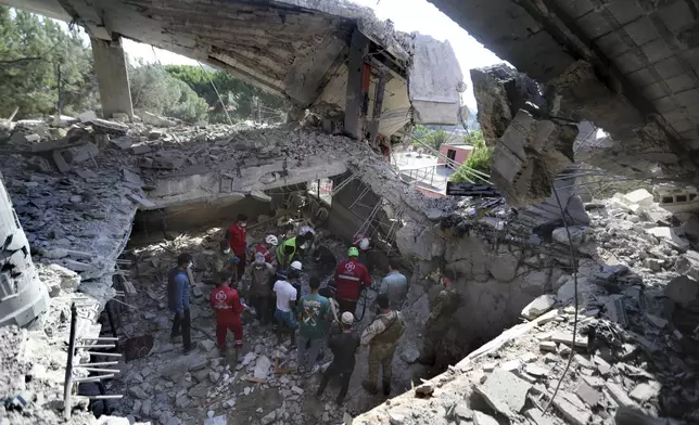 Rescue workers search for victims on a hotel-turned-shelter for displaced people hit by an Israeli airstrike, in Wardaniyeh, south Lebanon, Wednesday, Oct. 9, 2024. (AP Photo/Mohammed Zaatari)