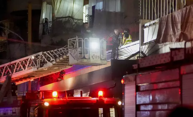 Emergency workers rescue an elderly man from a damaged building hit by an Israeli airstrike at the site of an Israeli airstrike in Beirut, Lebanon, Thursday, Oct. 10, 2024. (AP Photo/Hassan Ammar)