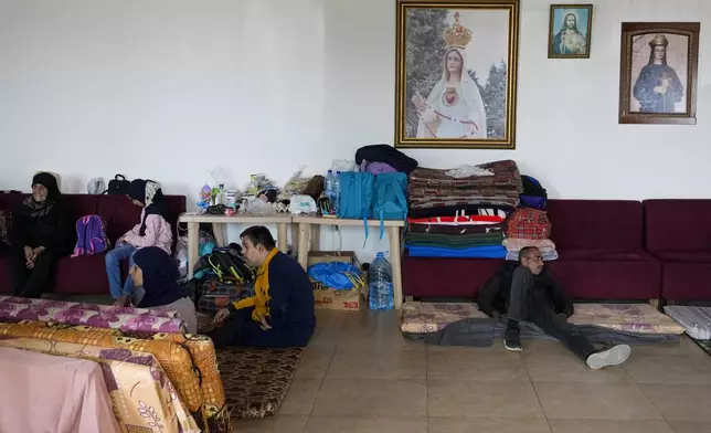 Displaced people, who fled Baalbek city and the nearby towns of Douris and Ain Bourday with their families amid the ongoing Hezbollah-Israel, take shelter inside a church sanctuary, in Deir Al-Ahmar, east Lebanon, Thursday, Oct. 31, 2024. (AP Photo/Hassan Ammar)