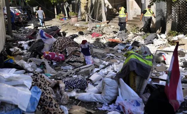 Hezbollah paramedics walk between debris after an airstrike hit an apartment in a multistory building, in central Beirut, Lebanon, Thursday, Oct. 3, 2024. (AP Photo/Hussein Malla)