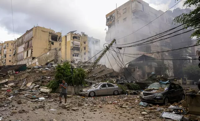 A man checks the damaged buildings at the site of an Israeli airstrike in Beirut's southern suburb, Lebanon, Tuesday, Oct. 1, 2024. (AP Photo/Hassan Ammar)