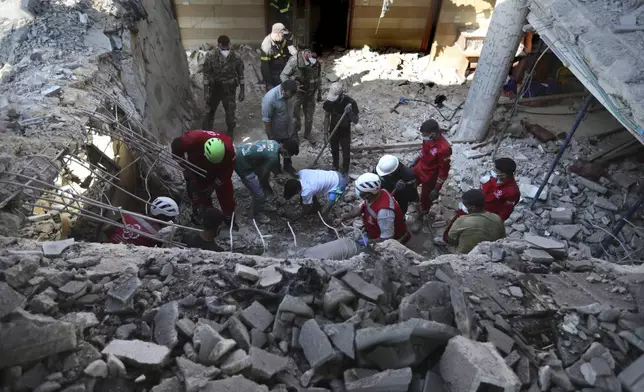 Rescue workers dig as they search for victims on a destroyed hotel-turned-shelter for displaced people hit by an Israeli airstrike, in Wardaniyeh, south Lebanon, Wednesday, Oct. 9, 2024. (AP Photo/Mohammed Zaatari)